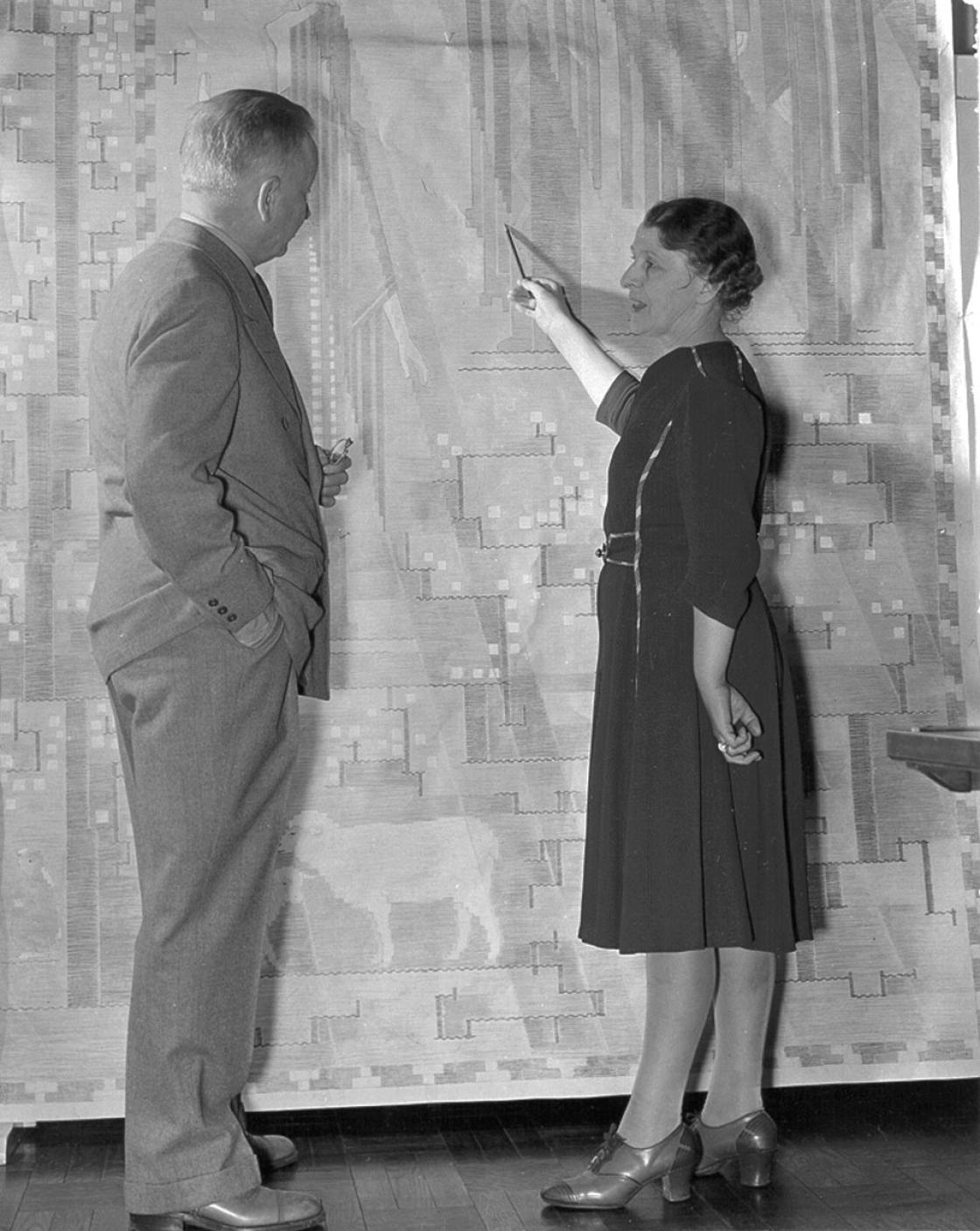 Loja Saarinen showing Eliel Saarinen a cartoon of their tapestry, The Sermon on the Mount, April 1941. Betty Truxell, photographer. Courtesy of Cranbrook Archives. Loja Saarinen showing Eliel Saarinen a cartoon of their tapestry, The Sermon on the Mount, April 1941. Betty Truxell, photographer. Courtesy of Cranbrook Archives.
