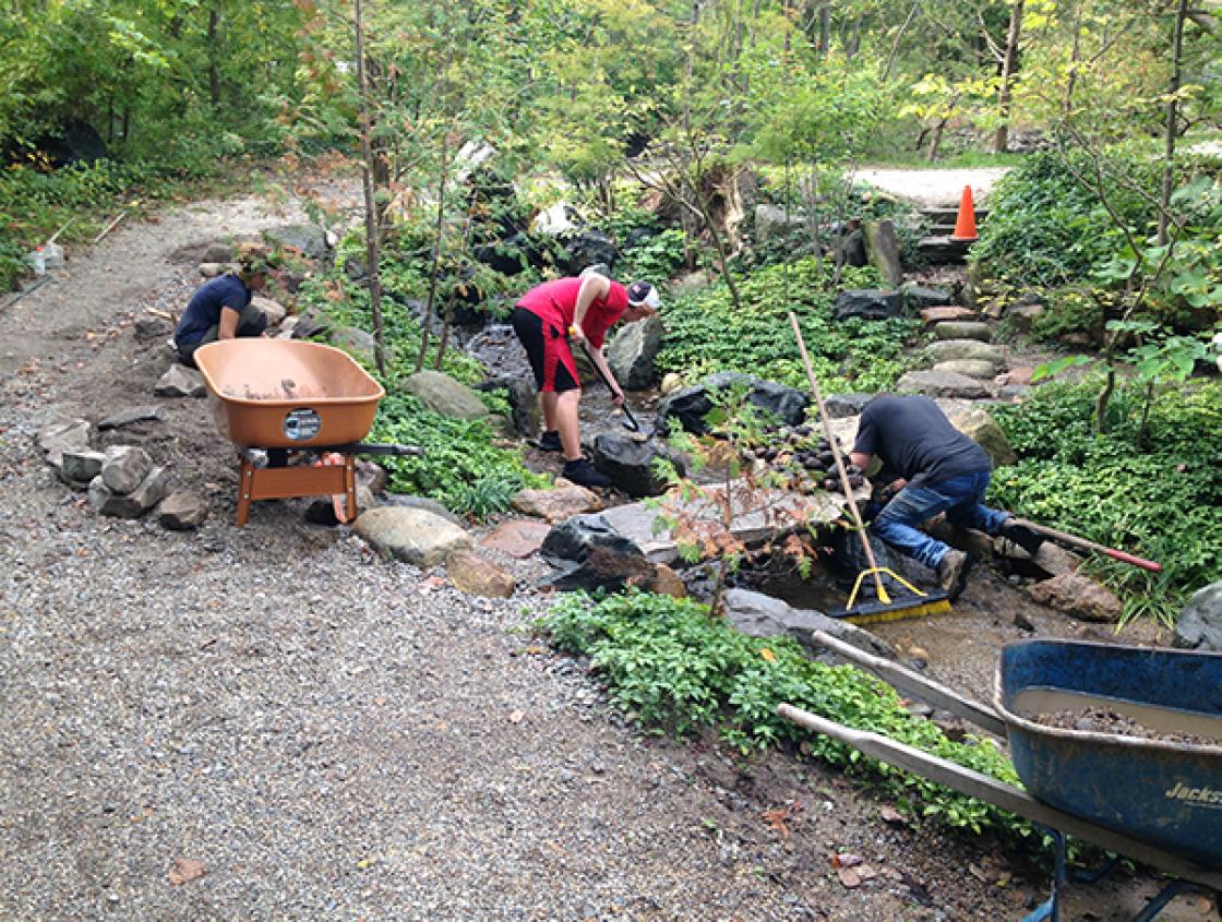 Emily Fronckowiak (far left) Set Stones Along the Edge of the Lily Pond Cascade and Remove Debris from the Stream Bed, October 1, 2019. Photography by Gregory Wittkopp.